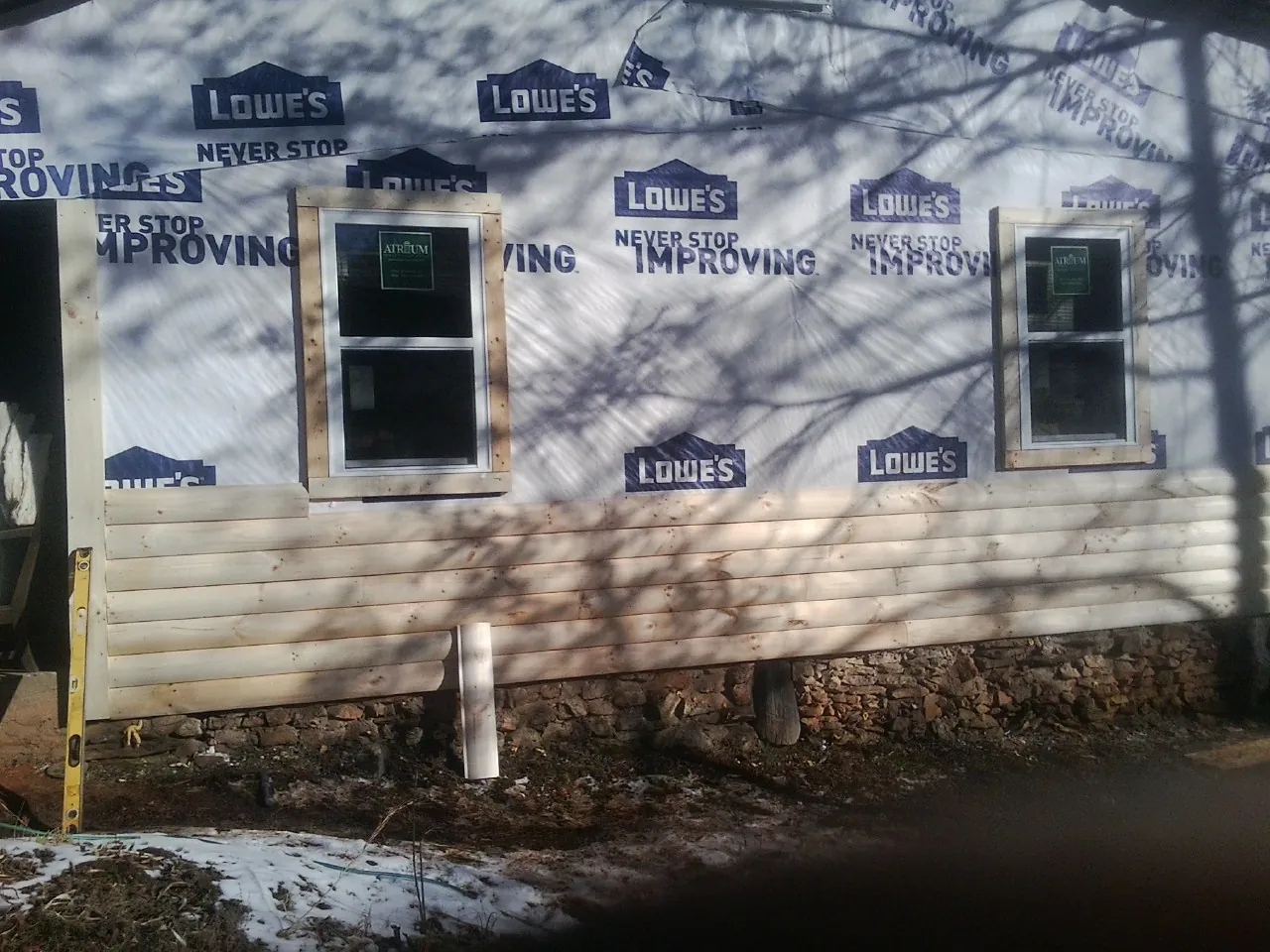House wrap and new log siding going up on an exterior wall in Saint Charles